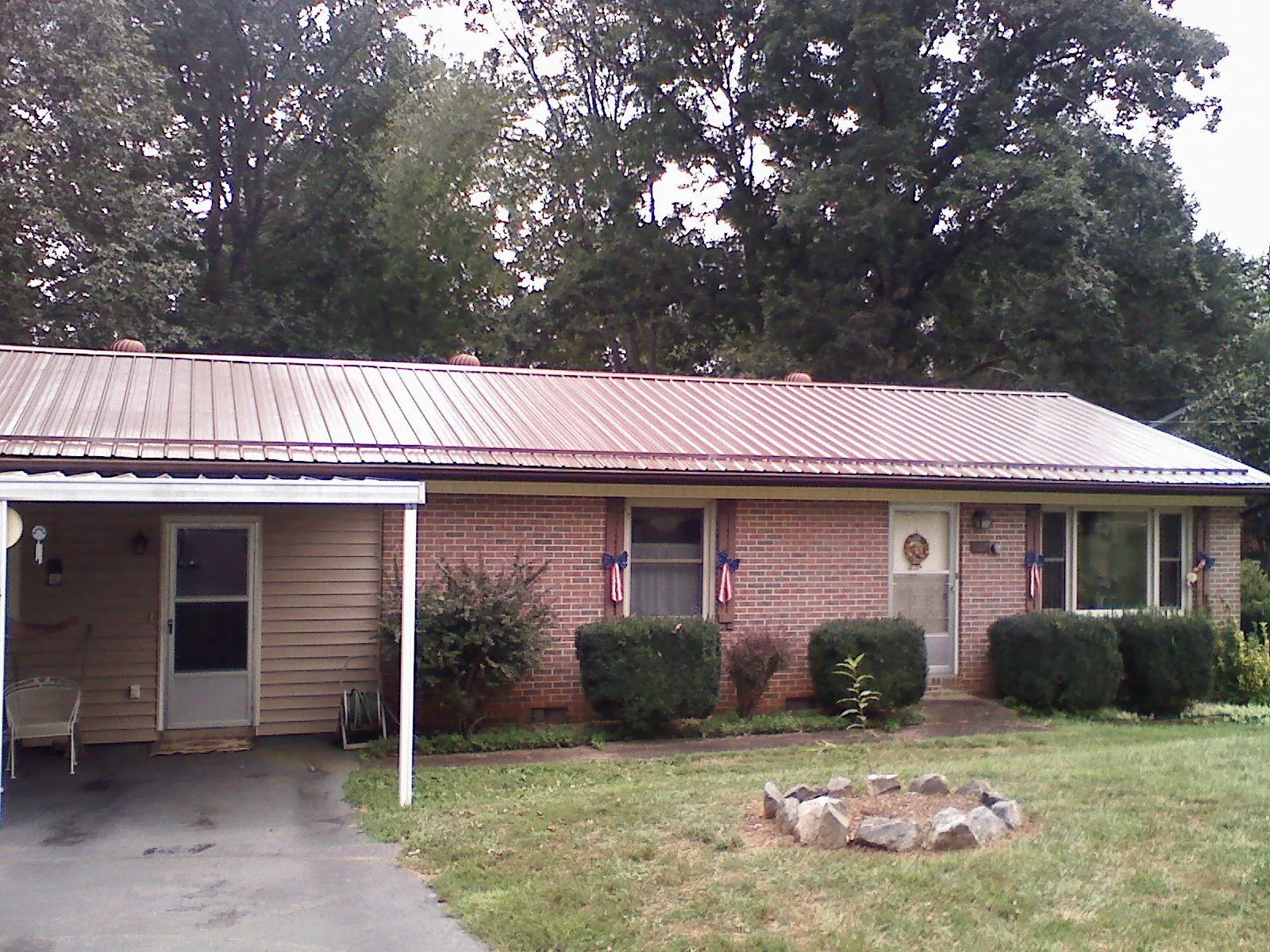Bronze metal roof and carport on a brick ranch home — Roof Repair work by our crew in Covington